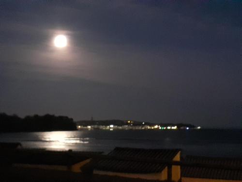 a full moon over a body of water at night at L'APPART DU RIS in Douarnenez