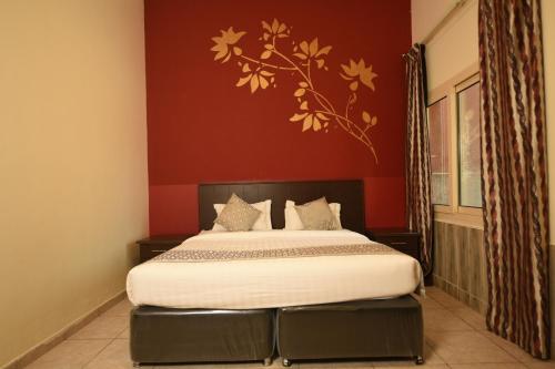 a bedroom with a bed with a red wall at Hotel & Resort Golden Marina Yanbu in Yanbu