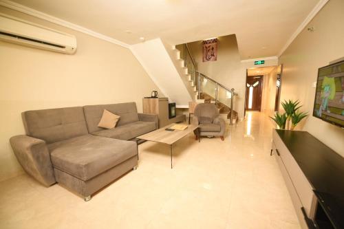 a living room with a couch and chairs and a staircase at Hotel & Resort Golden Marina Yanbu in Yanbu