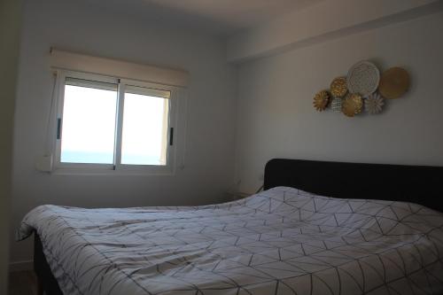um quarto com uma cama e uma janela em Calpe Beachview em Calpe