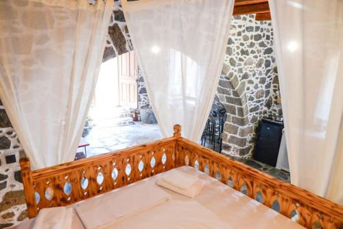 een kamer met een houten leuning en een raam bij Volcano View Nisyros in Emporeiós