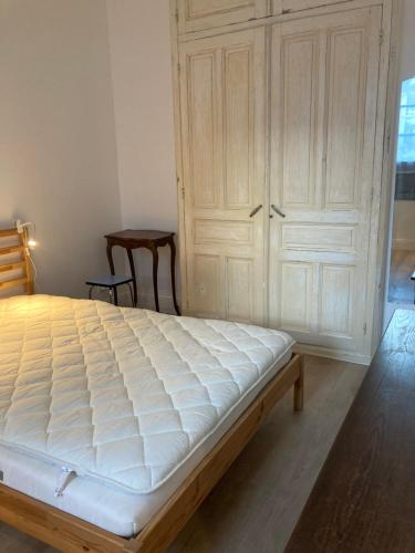 une chambre avec un lit blanc et un placard dans l'établissement JAZZ - Appart original 5pers rdch arrière cour calme, à Mulhouse