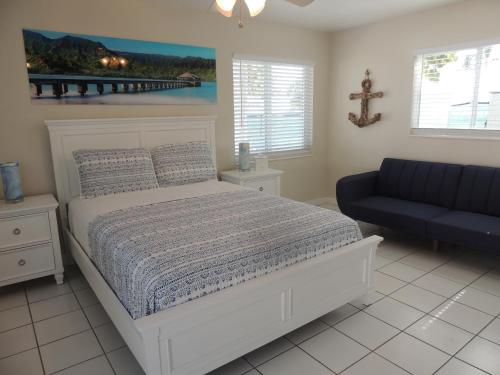 1 dormitorio con 1 cama blanca y 1 sofá azul en Sands of Islamorada, en Islamorada