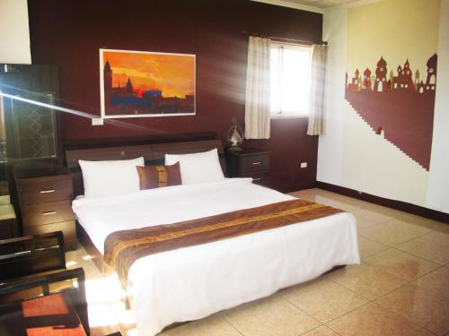 Un dormitorio con una cama grande y una ventana en Camellia B&B, en Taitung