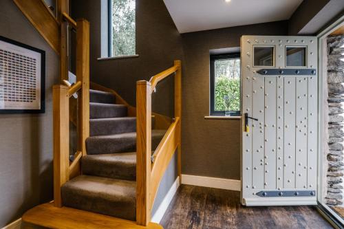 a hallway with a staircase and a door at Cleabarrow View in Windermere