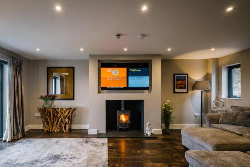 uma sala de estar com lareira e televisão em Cleabarrow View em Windermere