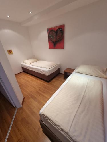 薩爾斯堡的住宿－Appartment Maxglan，一间卧室设有两张床,墙上挂着一幅画