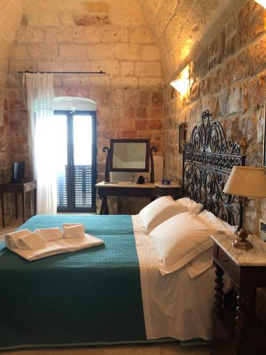 a bedroom with a bed and a table and a mirror at B&B Relais Del Senatore in Polignano a Mare