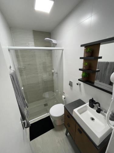 a bathroom with a shower and a toilet and a sink at Loft Studio 204 no Kobrasol à 7km de Floripa in São José