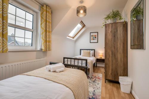 een slaapkamer met 2 bedden en een raam bij Central Belfast Apartments: Ashley Mews in Belfast