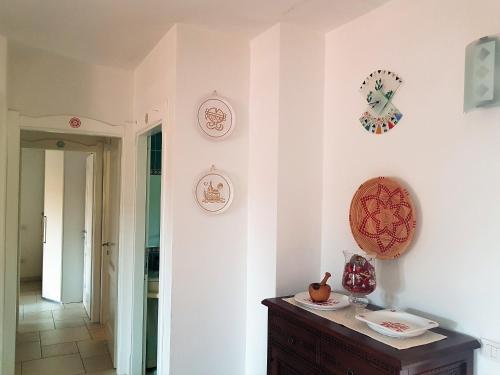 a room with white walls and clocks on the wall at Appartamento nel cuore di Villasimius 1 piano in Villasimius