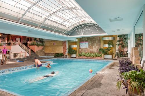 un grupo de personas jugando en una piscina en Hotel Libertador, en Loja