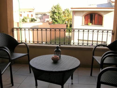 a table and chairs on a balcony with a fence at Appartamento nel cuore di Villasimius 1 piano in Villasimius