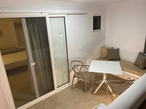 Ce petit appartement comprend une table et des chaises blanches. dans l'établissement Nikoletta Studios, à Ágios Prokópios