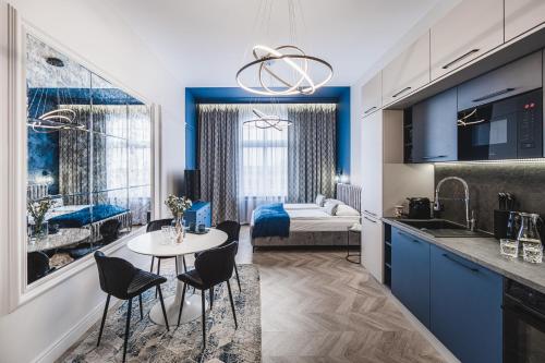 una cucina con tavolo e sedie e una camera da letto di Apartament 21A- Hvile Stay a Toruń