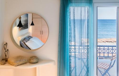 a bedroom with a mirror and a view of the ocean at Sagma calm apartment with amazing sea view in Perissa