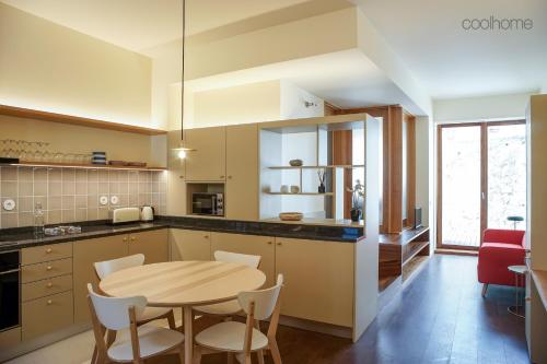 a kitchen with a wooden table and a table and chairs at 14 Calçada de Santiago in Vila do Conde