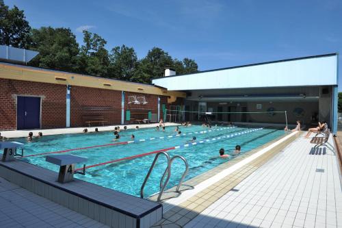 un groupe de personnes dans une piscine dans l'établissement Camping Hurongues, à Pomeys