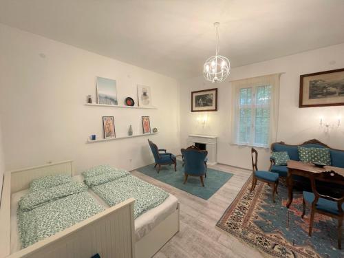 a bedroom with two beds and a table and chairs at Villa Bagolyvár in Balatonszemes