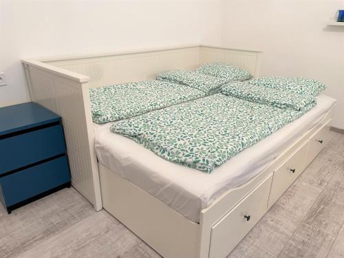 Una cama blanca con almohadas azules encima. en Villa Bagolyvár, en Balatonszemes