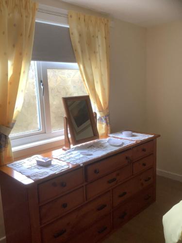 a dresser with a mirror on top of it in front of a window at Croft cabin in Fort William