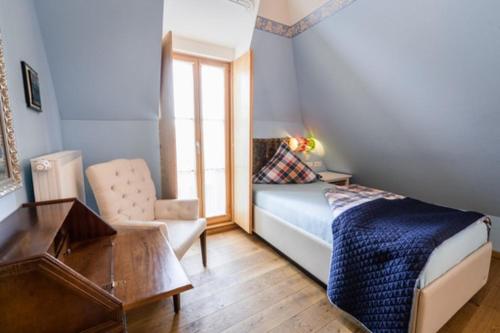 a bedroom with a bed and a chair and a desk at Hotel Belle Vue Volkach in Volkach