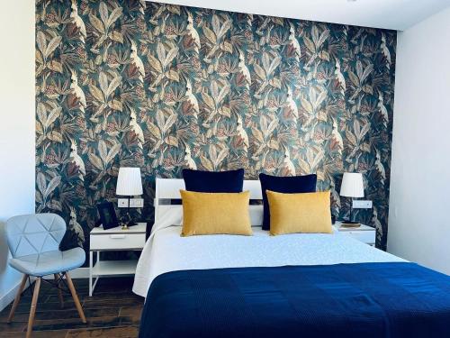 1 dormitorio con 1 cama grande y papel pintado con motivos florales en Bella Home en Garachico