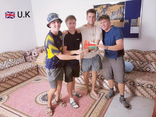 a group of four men standing in a living room at 228Hostel in Al Ḩamrāʼ