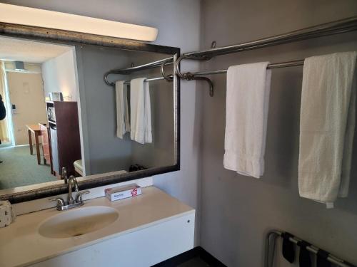 亨德森的住宿－121 Motel Henderson，浴室配有盥洗盆、镜子和毛巾
