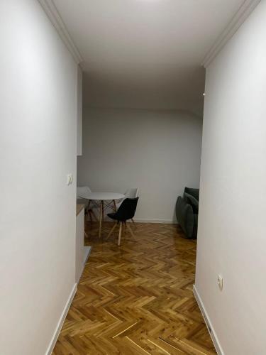 a room with white walls and a wooden floor at Stan centar ns in Novi Sad