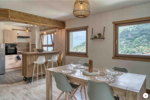 une cuisine et une salle à manger avec une table et des chaises dans l'établissement Chalet Mirador appartement vue panoramique SITUÉ À 25 kms de CHAMONIX, à Saint-Gervais-les-Bains