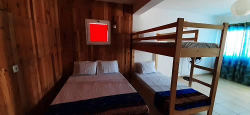 a bedroom with two bunk beds and a tv at Atlantic Sal Hostel in Santa Maria