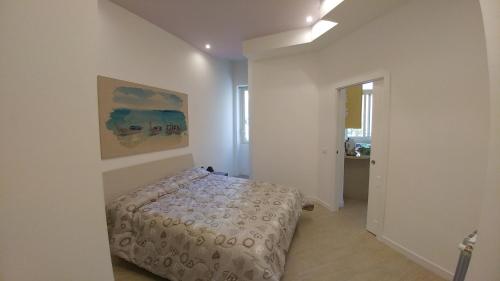 パレルモにあるKosié - il comfort di classe con 2 bagniのベッドルーム1室(ベッド1台付)が備わります。壁には絵画が飾られています。