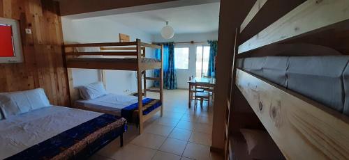 um quarto com 2 beliches e uma secretária em AH Xamedu Sal Hostel em Santa Maria