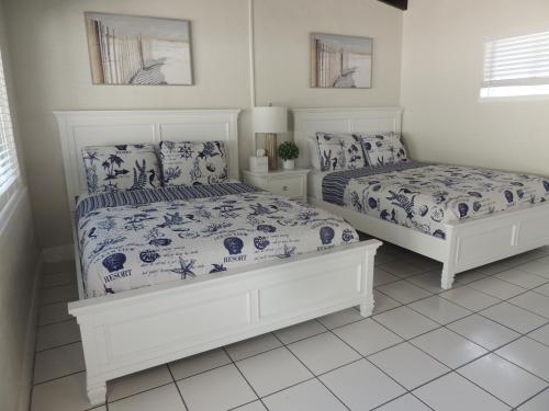 a bedroom with two beds with blue and white sheets at Sands of Islamorada in Islamorada