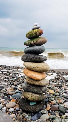 a stack of rocks on a rocky beach at Luxury Dreamland Oasis Apartments in Chakvi