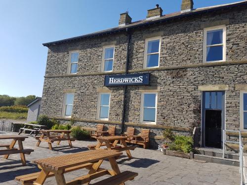 a group of picnic tables in front of a building at Herdwicks in Millom