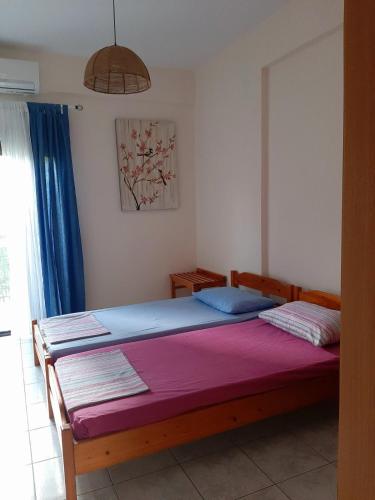 1 dormitorio con 1 cama grande con manta morada en CHALKIDIKI NEA PLAGIA, en Nea Plagia