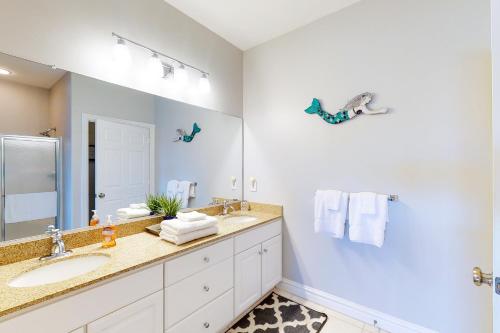 a bathroom with two sinks and a large mirror at The Sandbridge Dunes - Salty Mermaid 110 in Virginia Beach