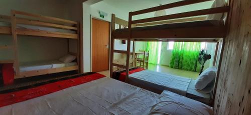 a room with two bunk beds and a room with another bed at Atlantic Sal Hostel in Santa Maria
