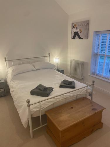 a bedroom with a bed with two towels on it at The House on the Common in Coity