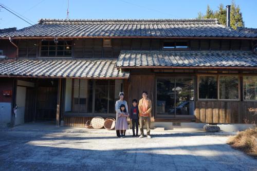 a group of three people standing in front of a building at Kominkayado oniwa - Vacation STAY 33168v in Hasami
