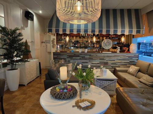 ein Wohnzimmer mit einem Tisch und einer Bar in der Unterkunft Hotel Sfinx in De Panne