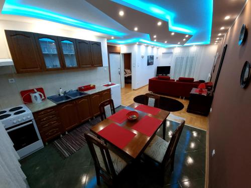 cocina y sala de estar con mesa y luces azules en Luxury Apartments Belgrade, en Belgrado