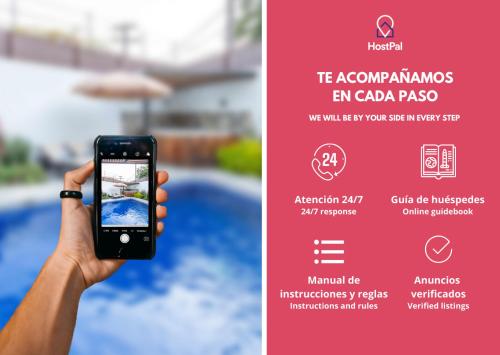 a person holding up a cell phone to take a picture of a pool at Spectacular House Tulipanes in Xochitepec