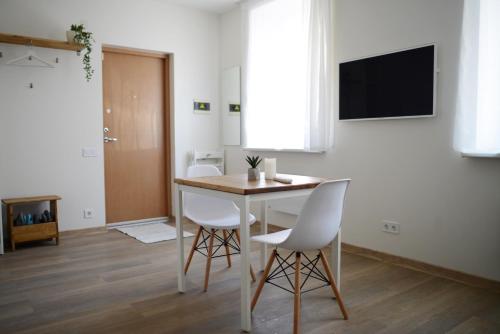 a dining room with a table and white chairs at City center apartment in Klaipėda