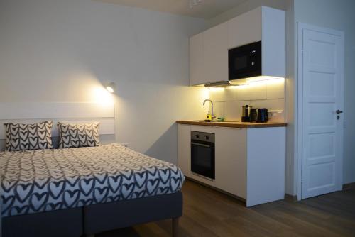 Kleines Zimmer mit einem Bett und einer Küche in der Unterkunft City center apartment in Klaipėda