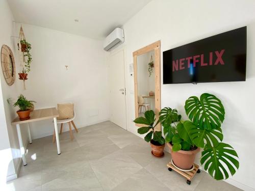 a living room with plants and a sign on the wall at Pathos Guest House in Quarto dʼAltino