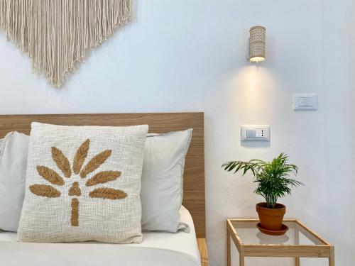 a bedroom with a bed with a pillow and a plant at Pathos Guest House in Quarto dʼAltino