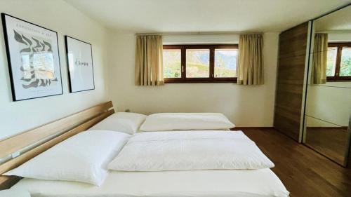 um quarto com 3 camas e uma janela em Ferienwohnung Geismayr em Dornbirn